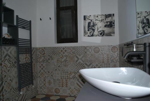 都灵CASA RITA e CASA LUIGI的浴室设有白色水槽,墙上挂有一些图片