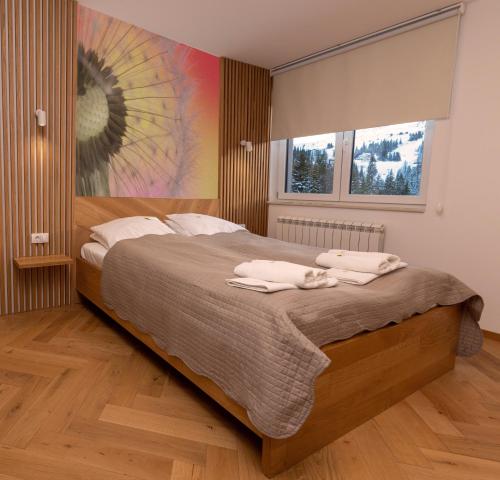 亚霍里纳Sunčani vrhovi的一间卧室配有一张大床和毛巾