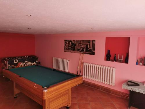 科贝拉古拉Usługi Noclegowe i Gastronomiczne dla Ludności Robert Mielcarek的红色墙壁的房间里设有一张台球桌