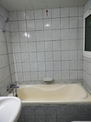 阿布扎比Hussaini Home的瓷砖浴室设有白色浴缸。