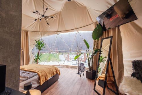 纳文丘夫Domki i Glamping Nałęczów - Pod Łysą Górą的一个带床位的卧室,位于一个植物帐篷内