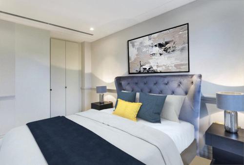 伦敦Modern Hammersmith Bridge Flat的一间卧室配有一张大床和蓝色床头板