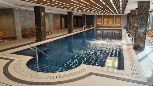 兹拉蒂博尔Sunny Mountain Apartment - Zlatibor, Serbia - SPA & WELLNESS CENTER的酒店大堂的大型游泳池
