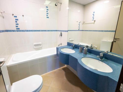 迪拜Avantha By Afi luxury 2BHK apartment的浴室配有2个盥洗盆、卫生间和浴缸。