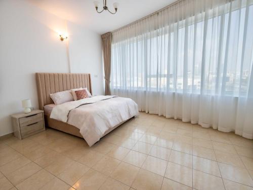 迪拜Avantha By Afi luxury 2BHK apartment的一间卧室设有一张床和一个大窗户