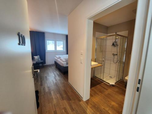施瓦尔茨湖Pension fein & sein的一间卧室配有一张床,一间设有淋浴。