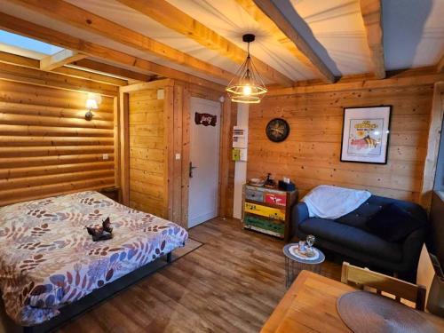 热拉梅Studio type chalet的一间卧室配有一张床和一个沙发