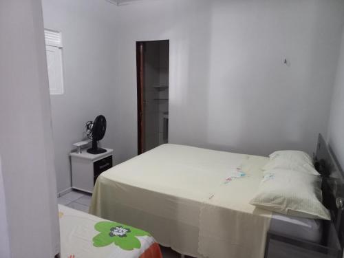 Serra de São BentoChácara Família Nacer的一间小卧室,配有一张床和一部电话