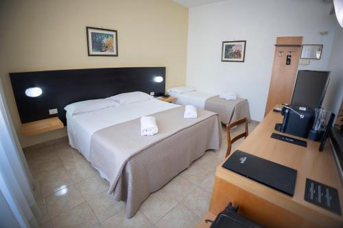 贝内文托Antum Hotel的酒店客房设有两张床和电视。
