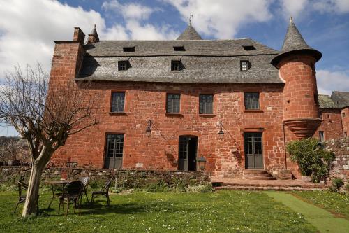 科隆热Château de Vassinhac chambres d'hôtes Collonges la rouge的一座带烟 ⁇ 的古老红砖建筑