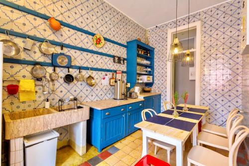 里斯本安比恩特旅舍的厨房配有蓝色橱柜和桌椅
