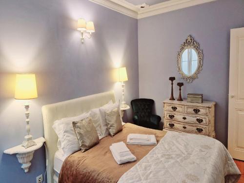 里斯本里斯本上城芭提奥博阿文图拉公寓的一间卧室配有一张带梳妆台和镜子的床