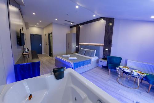 伊斯坦布尔Meros Hotel的带浴缸的大浴室和带一张床的房间