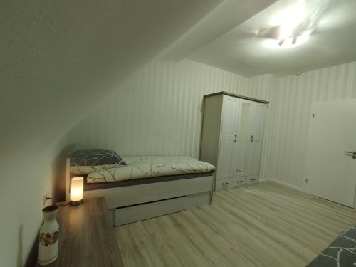 斯图加特Nah an Mercedes-Werke的一间卧室配有一张床和一个橱柜