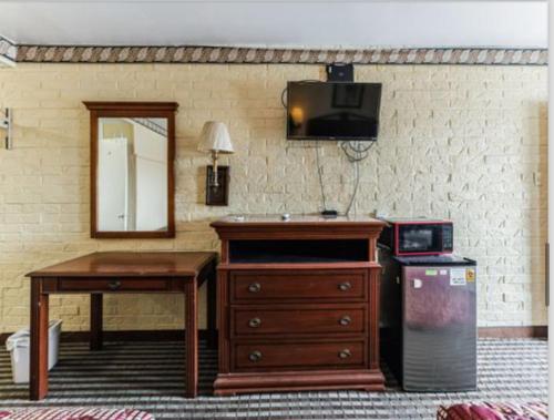 福雷斯特城Regency Inn的一间设有梳妆台、桌子和镜子的房间