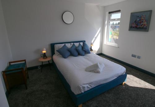 纽波特Self-Service En-Suite Rooms by Property Promise的一间卧室配有一张带蓝色枕头的床和一扇窗户。
