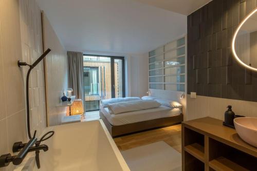 维也纳Kleines Stadthaus in Toplage的一间带床、浴缸和水槽的浴室