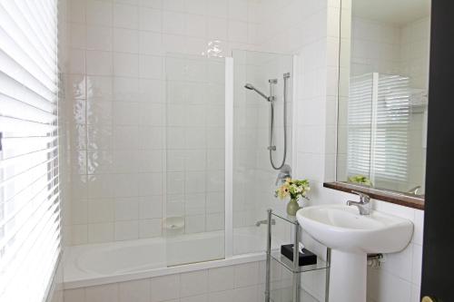 汉默温泉Hanmer Springs Hotel的白色的浴室设有水槽和淋浴。