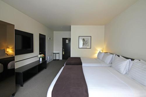 汉默温泉Hanmer Springs Hotel的一张大白色的床,位于酒店客房内