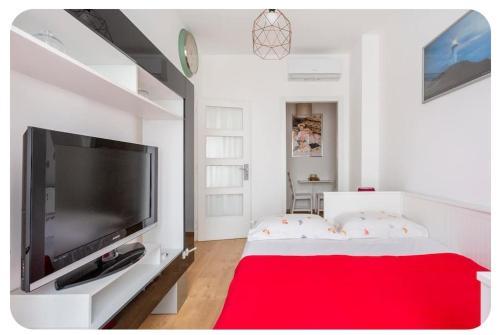 米兰Casa Rizzoli - bilocale vicinissimo M2的客厅配有大电视和红色地毯