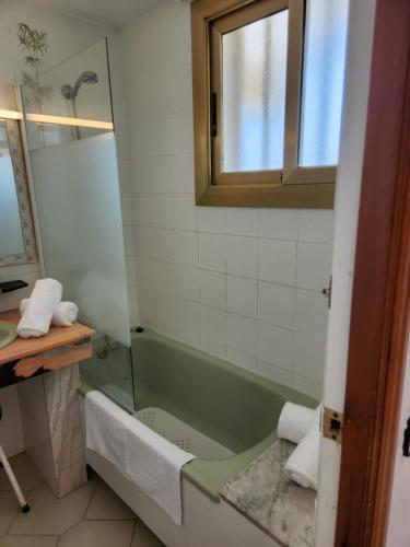 萨洛Apartments Novelty的浴室配有绿色浴缸和水槽