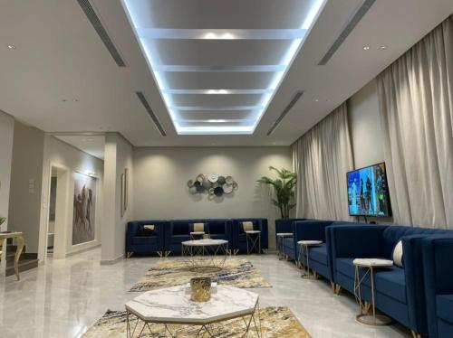 Yanbu Al Bahrشاليه رحال的一间设有蓝色沙发和电视的等候室