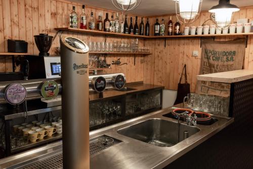 多克西Penzion a Restaurace Kamínek的厨房配有水槽和带瓶子的台面