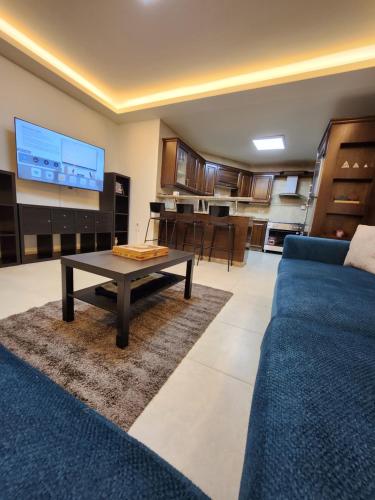 安曼Dair Ghbar - Amman Apartment的客厅配有蓝色的沙发和桌子