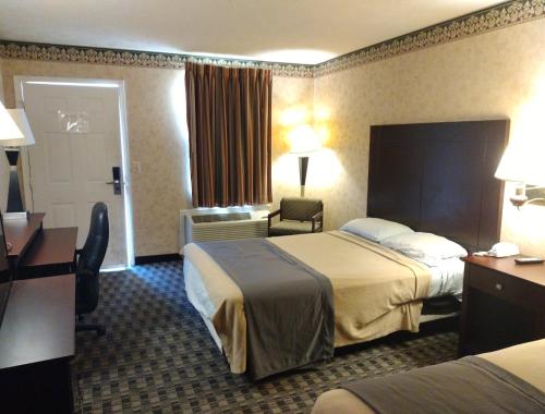 CounceStonebrook Inn的酒店客房配有两张床和一张书桌