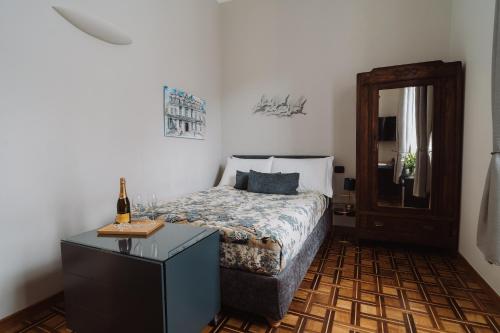 热那亚Il Giardino della Tartaruga的一间卧室配有一张床和一张桌子及一瓶葡萄酒