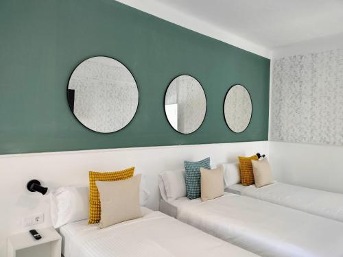 拉拉古纳Room27的客厅配有白色沙发和三面镜子