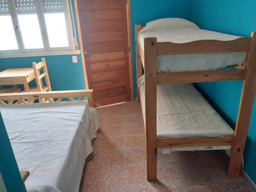 Colonia ChapadmalalLa Huella的蓝色墙壁的客房内设有两张双层床。