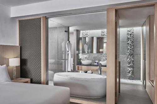新加坡Singapore Marriott Tang Plaza Hotel的带浴缸和盥洗盆的浴室的 ⁇ 染