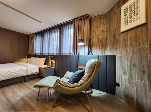 花莲市花蓮品悅文旅Hualien Pink Corner Hotel的一间卧室,卧室内配有一张床和一把椅子