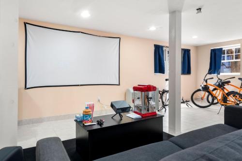 马布尔黑德Hot Tub, Electric Bikes, Solo Stove, Projector, Smores的带沙发和投影屏幕的客厅