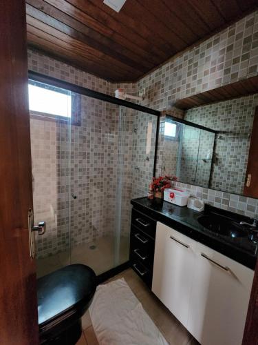 格拉瓦塔Belíssima casa de campo na serra em Gravatá PE的带淋浴、盥洗盆和镜子的浴室