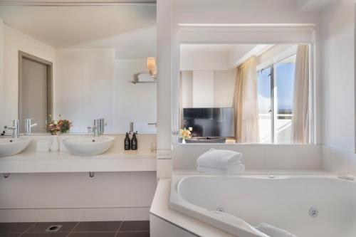 基督城Fable Christchurch的白色的浴室设有2个盥洗盆和1个浴缸。