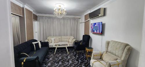 开罗Comfortable Apartment in sheraton Heliopolis 5 minutes from Cairo Airport的客厅配有沙发、椅子和电视