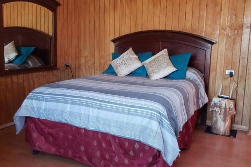 皮尔克Cabaña的一间卧室配有一张带蓝色和白色枕头的床