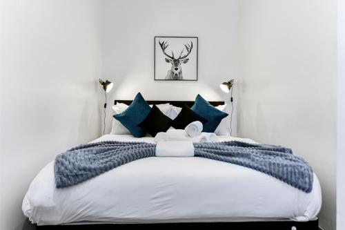 HanwellVibrant 1 BD Retreat - Perfect for Couples的一间卧室配有一张带蓝色枕头的大床