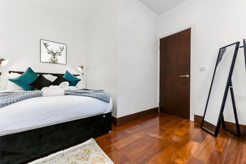 HanwellVibrant 1 BD Retreat - Perfect for Couples的一间卧室设有一张大床,铺有木地板