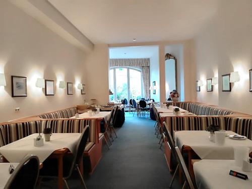 波恩Hotel Mozart Bonn的餐厅内带桌椅的用餐室