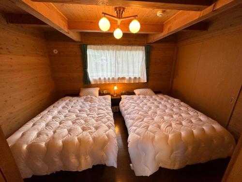 舞鹤市舞鶴ふるるファームコテージ的带窗户的客房内设有两张大床