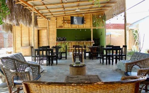 曼克拉Pascana Casa Playa的一间设有桌椅的餐厅,并在露台上配有电视