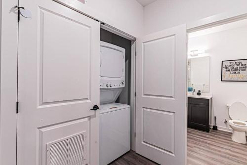 Posh Living Condo的一间带卫生间和白色门的浴室