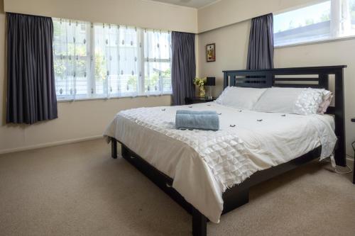 汉密尔顿Glenview home的卧室配有一张带白色床单和窗户的大床。