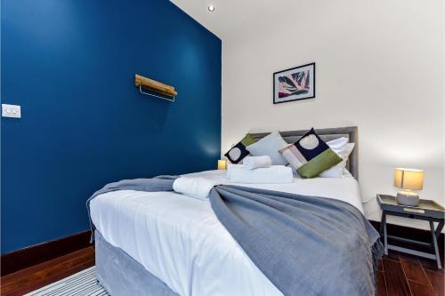 HanwellLovely 2-bedroom rental unit in Greater London的一间卧室设有蓝色墙和一张床