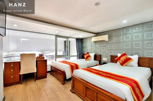 胡志明市HANZ King Airport Hotel的酒店客房配有两张床和一张书桌