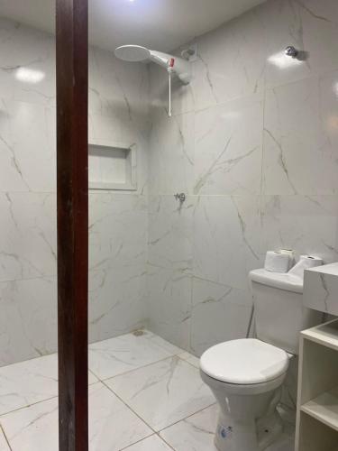 阿拉瓜伊纳Flat suítes mobiliados central的白色的浴室设有卫生间和淋浴。