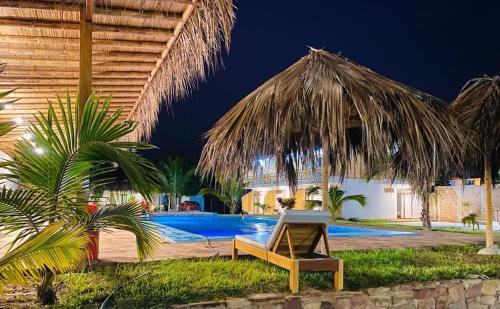 曼克拉Pascana Casa Playa的一个带椅子的度假村和一个夜间游泳池